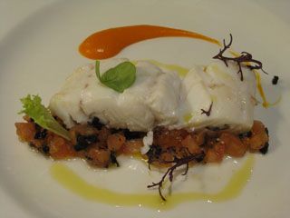 Merluza a la sal sobre cama de tomate