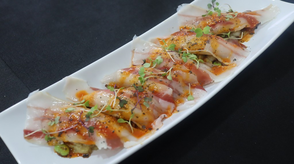 Magano con papada sobre berenjena asada al soplete